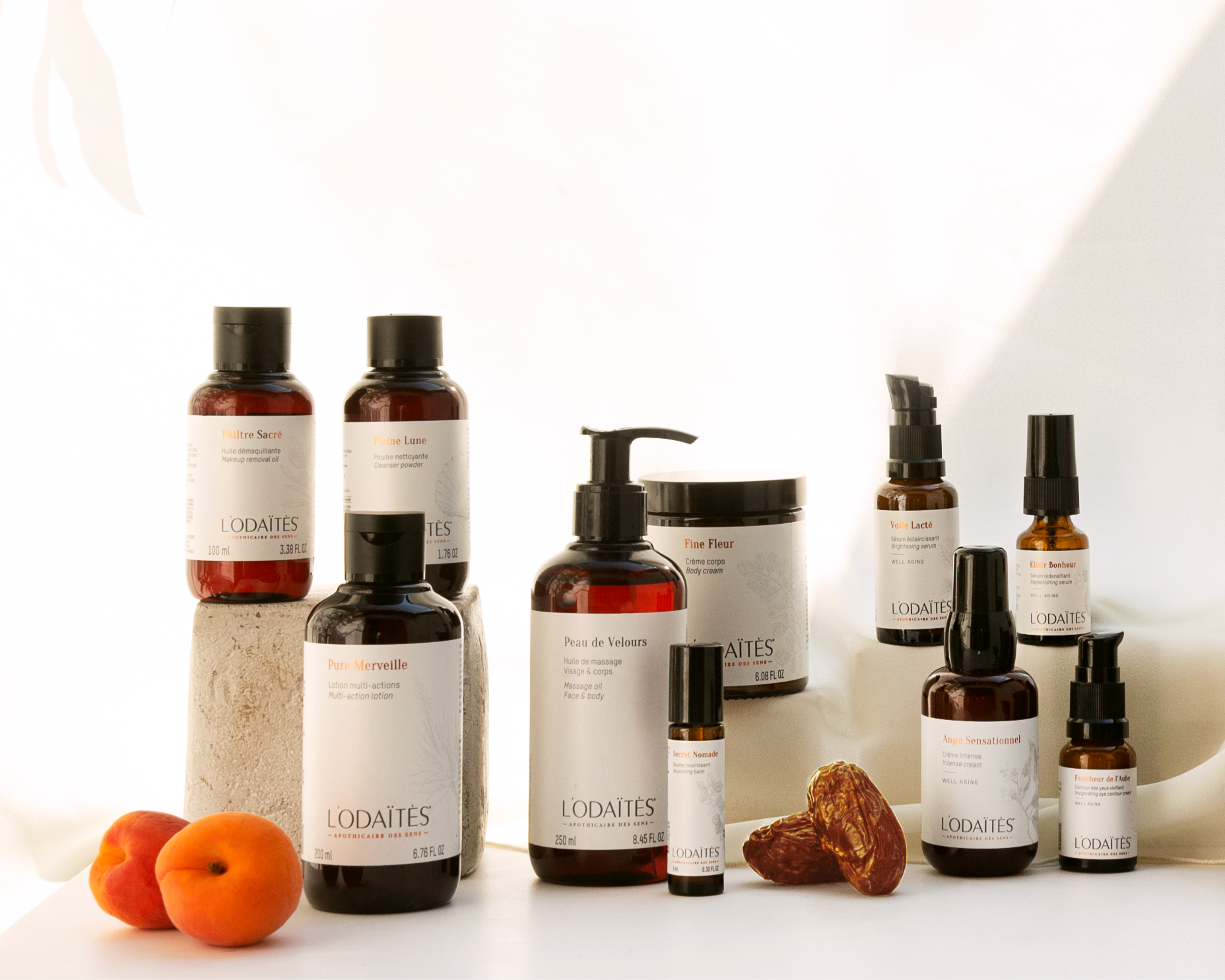 L’ODAÏTÈS natural skincare collection with date fruit, featuring cleansers, serums, and creams in amber glass bottles.