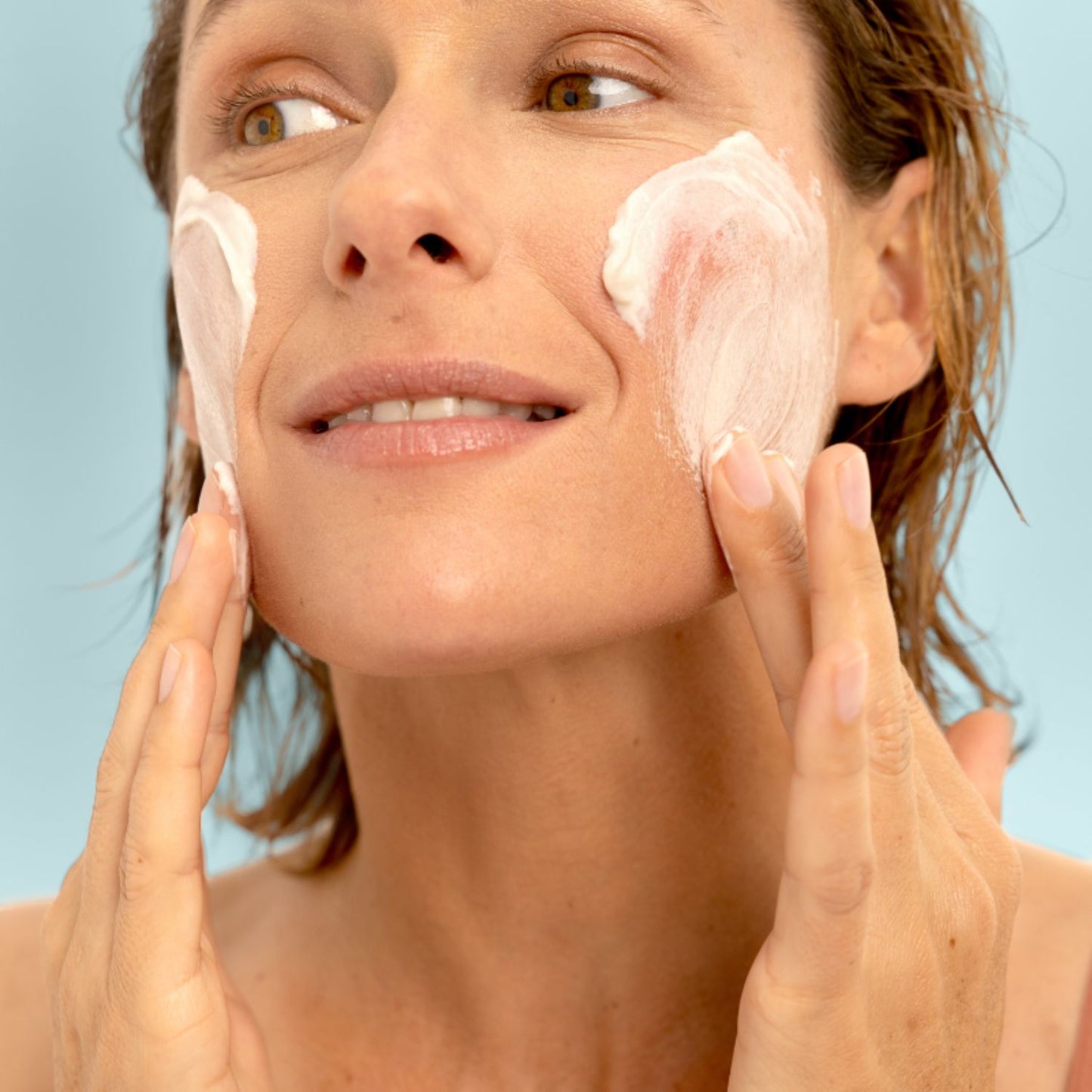 Model applying LIA Cosmétiques Creamy Powder Facial Cleanser, transforming powder into a creamy texture