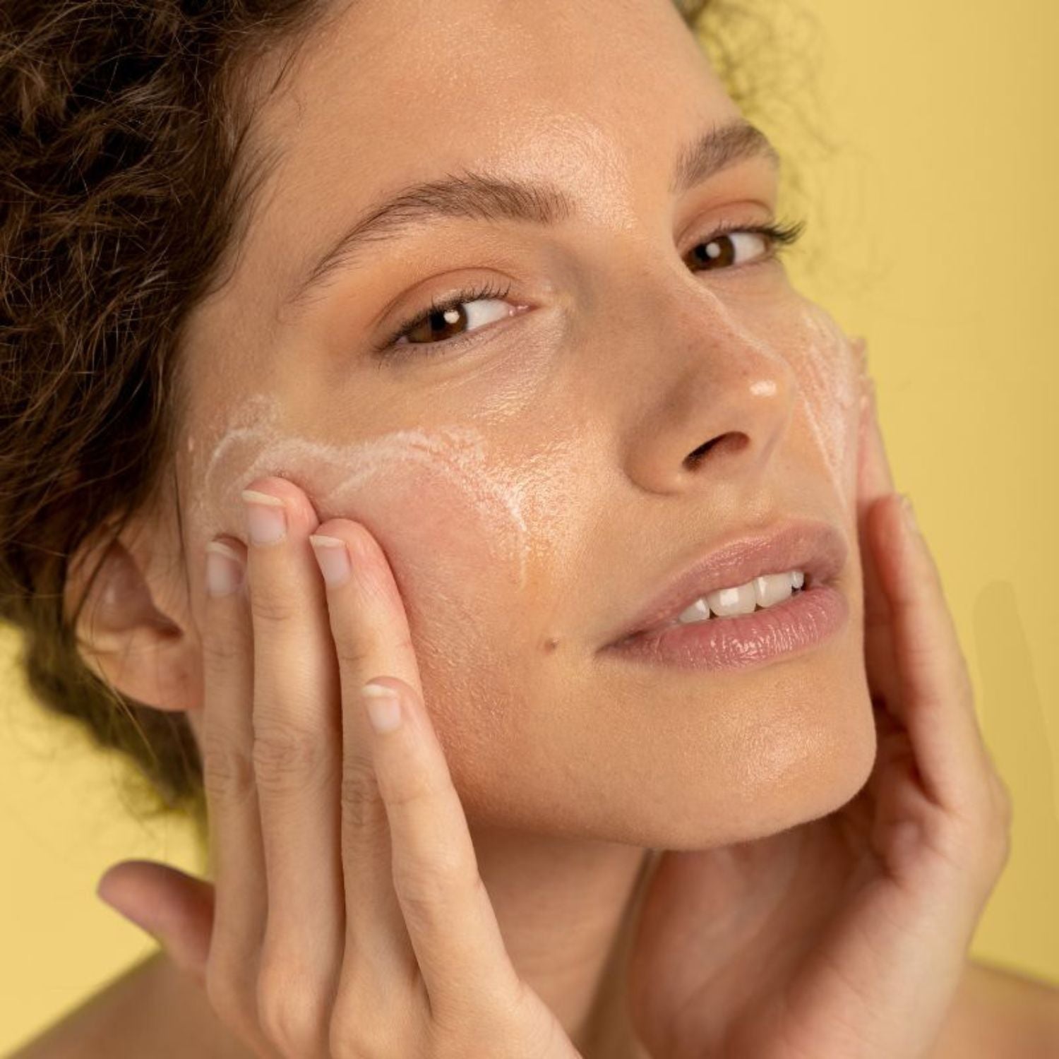 Woman applying LIA Cosmétiques Fine Milky Cleansing Oil to remove makeup and impurities