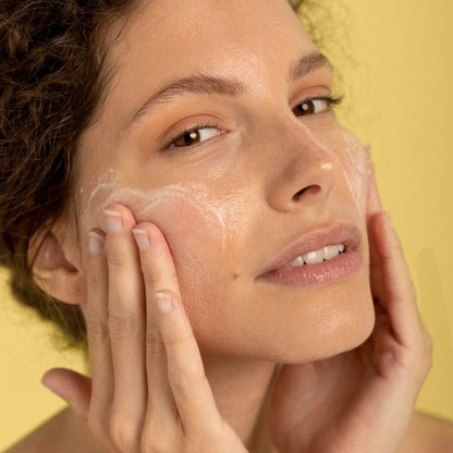 Woman applying LIA Cosmétiques Fine Milky Cleansing Oil to remove makeup and impurities