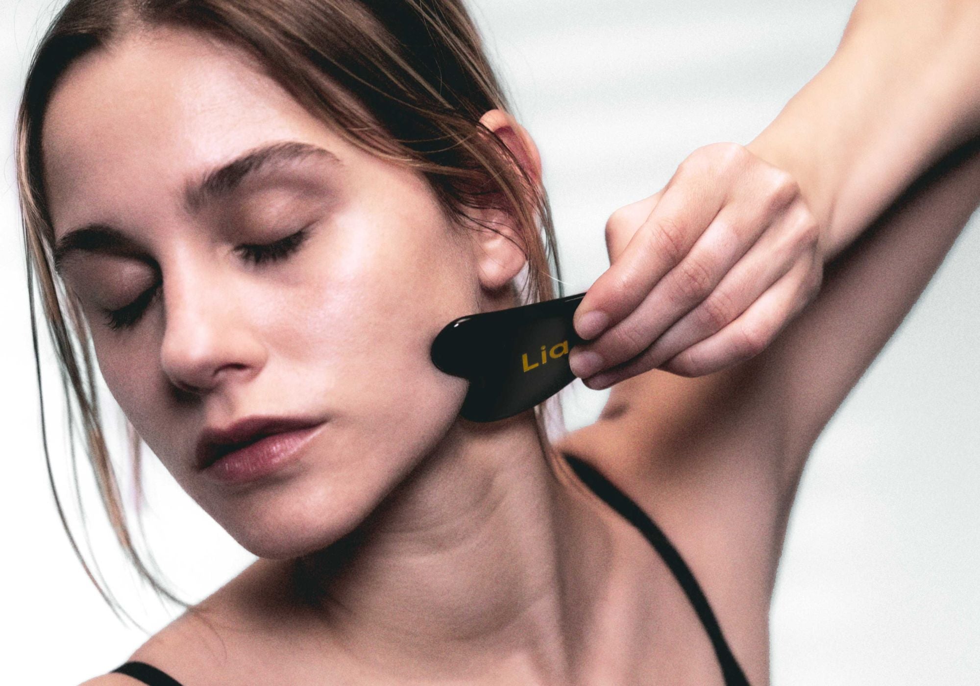 Laboratoire Lia gua sha tool in use. Premium organic natural skincare available at Ô Naturel Boutique UAE.